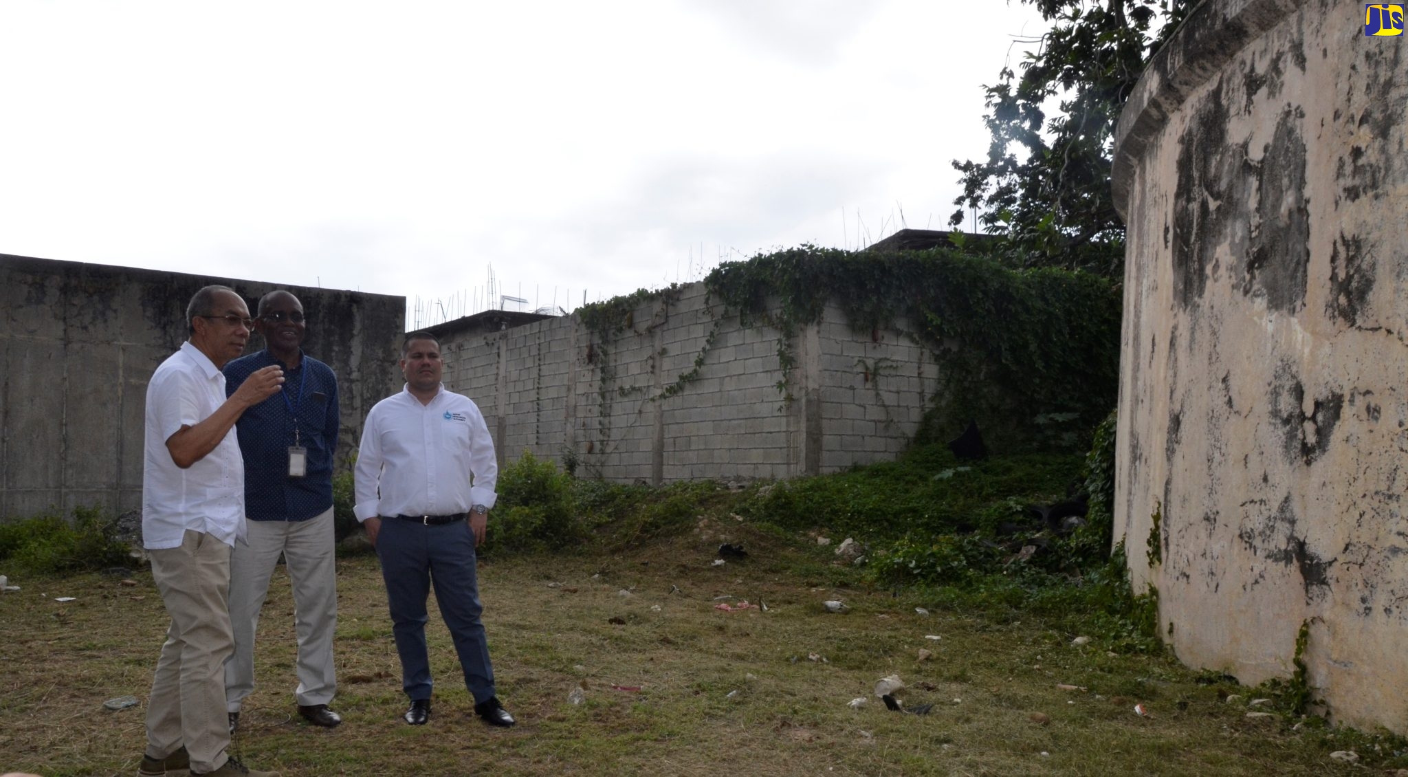 Minister without Portfolio in the Ministry of Economic Growth and Job Creation, Senator the Hon. Matthew Samuda (right), is shown a water tank in Norwood, St. James, by Minister of National Security and Member of Parliament for St. James North Western, Hon. Dr. Horace Chang (left), during a tour of the community on Thursday (May 18). Accompanying the Ministers on the tour was Water Production Manager for St. James and Trelawny at the National Water Commission (NWC), Fitzgerald Roach (centre).