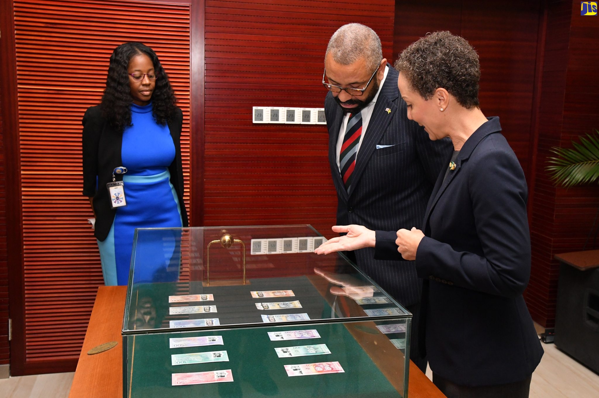 Minister of Foreign Affairs and Foreign Trade, Senator Hon. Kamina Johnson Smith (right), explains features of the new banknotes commemorating Jamaica 60th anniversary to Secretary of State for Foreign, Commonwealth and Development Affairs of the United Kingdom, the Rt. Hon. James Cleverly, following the Jamaica-United Kingdom strategic dialogue at the Ministry’s downtown Kingston offices on May 19. At left is Currency Operations Manager, Bank of Jamaica, Kamla Louden Dawkins. The banknotes, produced by, De La Rue, a British company, will soon be in circulation.