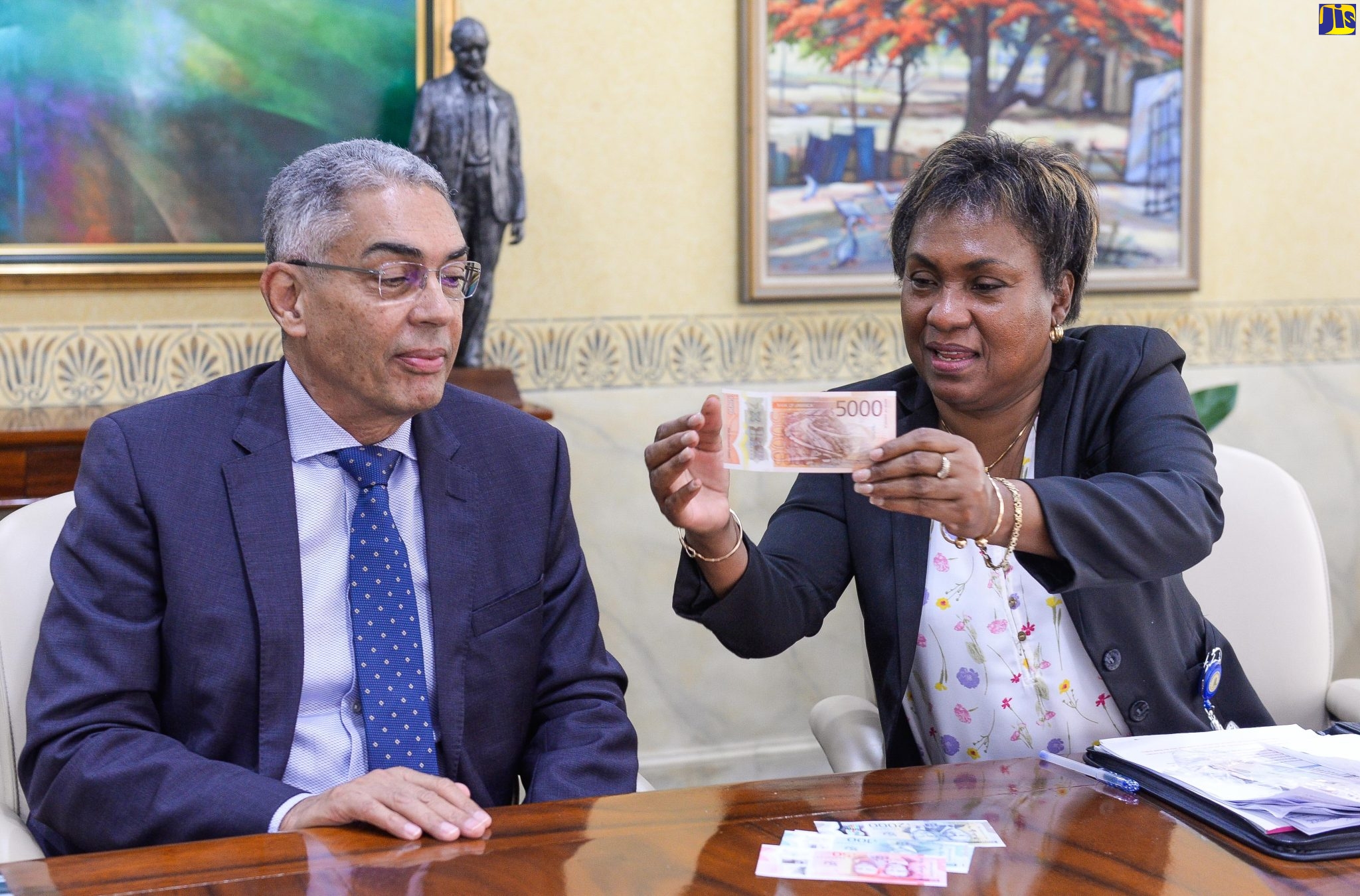 Bank of Jamaica (BOJ) Governor, Richard Byles (left), examines features on the new $5000 note being highlighted by BOJ Division Chief for Banking and Currency Operations, Chevanese Morais.