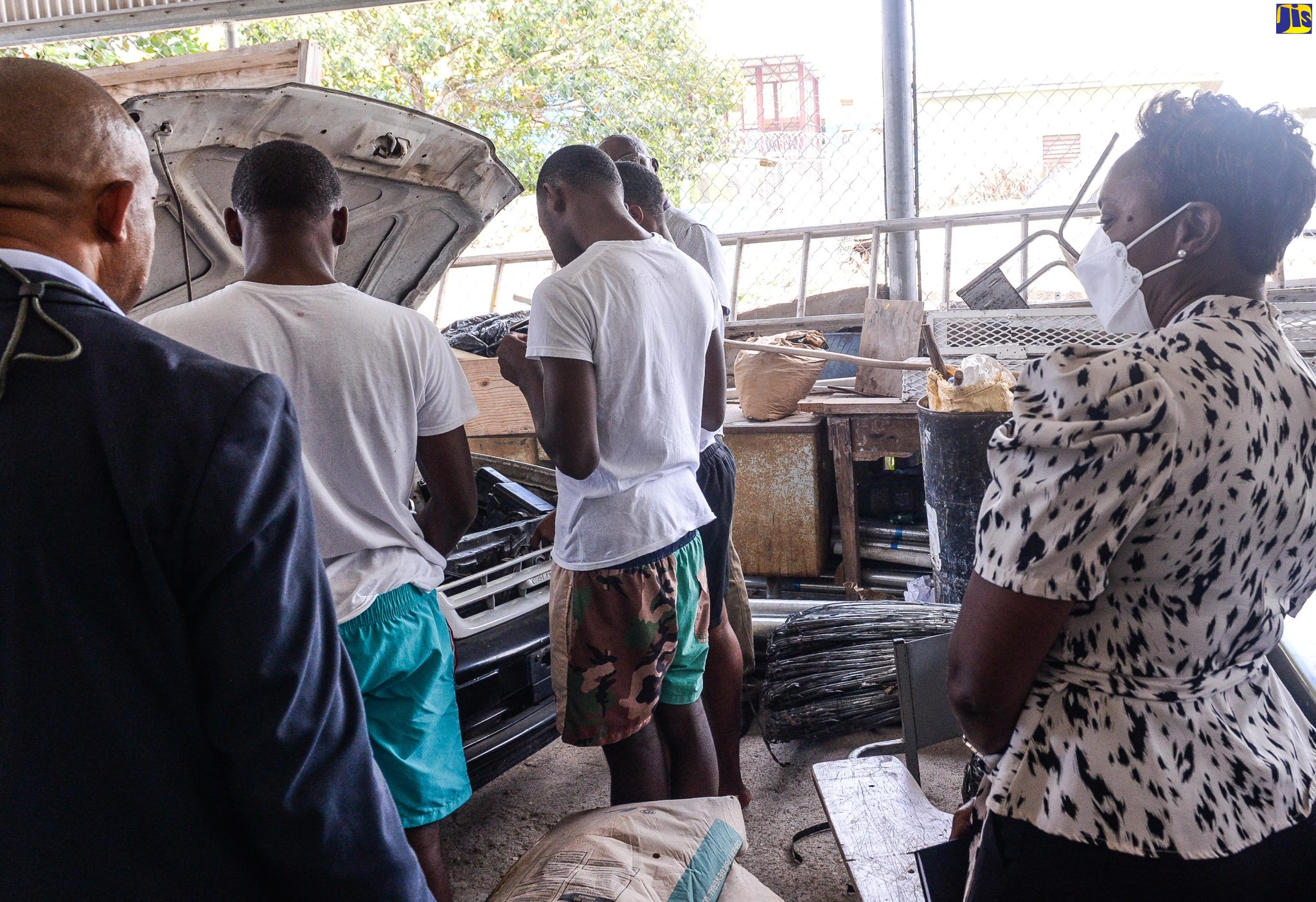 Minister of State in the Ministry of National Security, Hon. Juliet Cuthbert-Flynn (right), observes wards repairing a motor vehicle at the Rio Cobre Juvenile Correctional Centre in Spanish Town, St. Catherine, on Monday (June 19). At left is Acting Superintendent, Department of Correctional Services (DCS), Ian Henry.