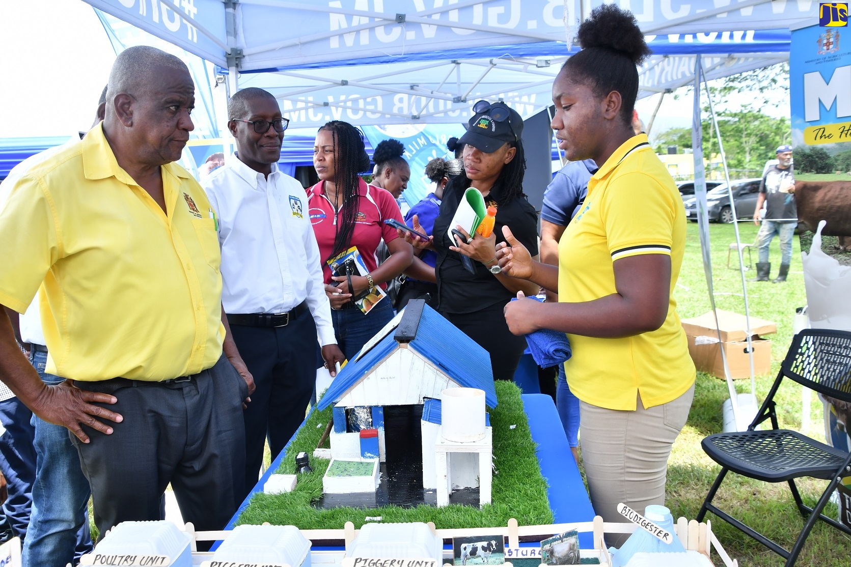 State Minister in the Ministry of Agriculture, Fisheries and Mining, Hon. Franklin Witter (left), engages with a student at the HEART/NSTA Trust Ebony Park Academy, Shavana Ellis (right), while touring booths at a World Milk Day function held on Thursday (June 1) at the Sydney Pagan STEM Academy in St Elizabeth. Looking on is Principal, Sydney Pagan STEM Academy, Milbert Miller (second left).