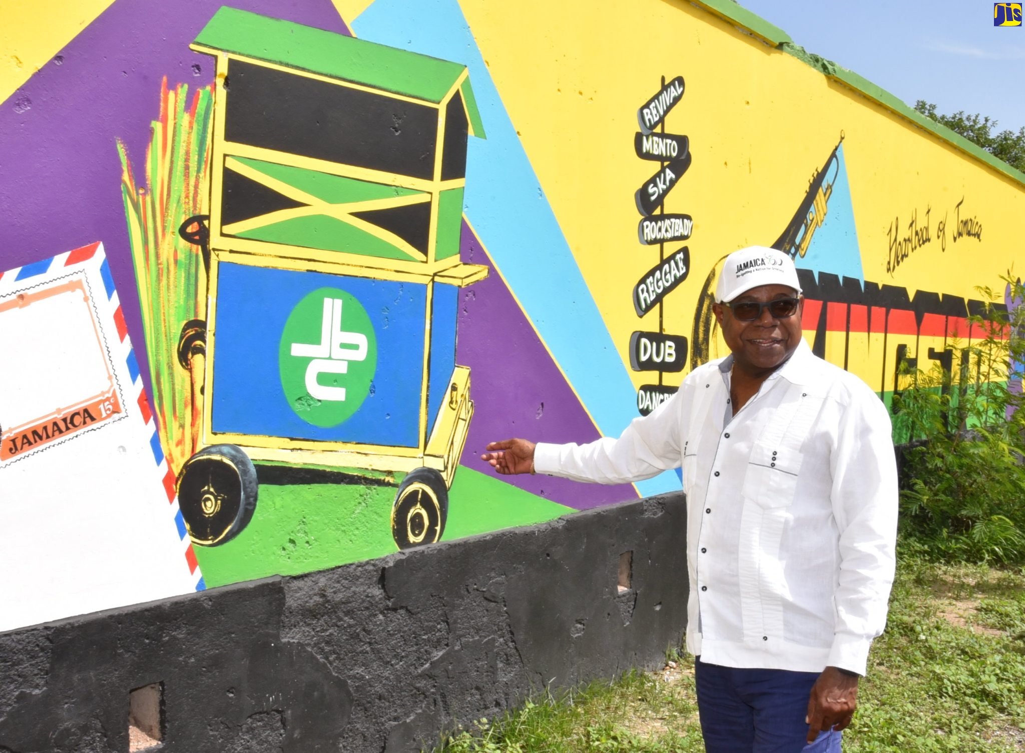 Minister of Tourism, Hon. Edmund Bartlett, points to a mural on a wall along South Camp Road on Friday (June 16). Occasion was a destination assurance tour of spots in Kingston and St. Andrew. Among the sites visited were the Grand Excelsior Hotel, Rae Town Fishing Village, and Victoria Pier.
