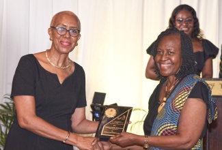 Minister of Education and Youth, Hon. Fayval Williams (left), presents an award to Pastor Claudia Ferguson for dedicated and faithful service to the United Church of the Seventh-day Baptist Churches and the Kingston Seventh-day Baptist Church. Pastor Ferguson was recognised during the 100th Anniversary Banquet of the Jamaica Seventh-day Baptist Conference of Churches held at the Terra Nova All-Suite Hotel in St. Andrew on July 2.
