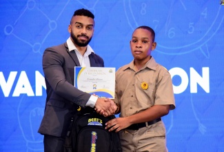 Director, Bert’s Auto Parts, Bert Tomlinson Jr. (left), presents a certificate of recognition to grant recipient, Evandre Dixon, during the inaugural staging of the Bert’s Auto Parts Foundation scholarship awards ceremony at The Jamaica Pegasus hotel in New Kingston on Tuesday (August 22). A total of 35 students were recognised for performing outstandingly in the 2023 Primary Exit Profile (PEP) examinations.