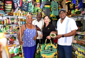 Minister of Tourism, Hon. Edmund Bartlett (right), shares a photo opportunity with (from left) business operator in the Port Antonio Craft Village, Jennifer Brown; Mayor of Port Antonio, Councillor Paul Thompson, and Member of Parliament, Portland Eastern, Ann Marie Vaz, during the recent destination assurance tour of sections of Portland where the Minister and other representatives met and engaged with stakeholders in the parish. The visit formed part of a series of islandwide tours of tourism entities and national stakeholder and public consultations on the Tourism Ministry’s Destination Assurance Framework and Strategy (DAFS). The DAFS serves as a long-term blueprint to guide the Ministry and its partners to strengthen, further develop and implement strategies that will ensure continuous improvement in the delivery and management of quality outputs throughout the tourism value chain.