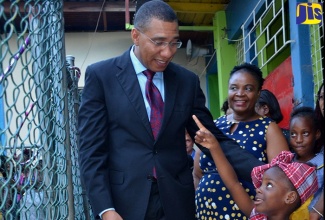 Prime Minister, the Most Hon. Andrew Holness (left), enjoys a playful moment with Seaward Primary and Junior High School student, Kerica Thomas. Occasion was a ceremony to open a play area and honour stakeholders at the institution at Olympic Way, St. Andrew, on July 25, 2019. Looking on in the background is the Principal, Arlene Thomas.