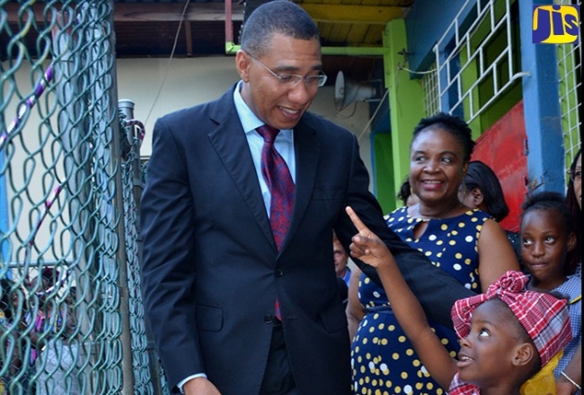Prime Minister, the Most Hon. Andrew Holness (left), enjoys a playful moment with Seaward Primary and Junior High School student, Kerica Thomas. Occasion was a ceremony to open a play area and honour stakeholders at the institution at Olympic Way, St. Andrew, on July 25, 2019. Looking on in the background is the Principal, Arlene Thomas.