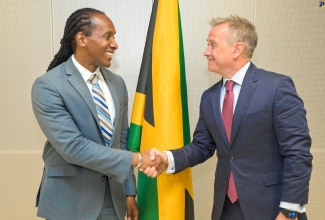 Minister of State in the Ministry of Foreign Affairs and Foreign Trade, Hon. Alando Terrelonge (left), greets Jamaica’s Honorary Consul in Uruguay, Jorge Elissalde, during the diplomat’s courtesy call at the Ministry in downtown Kingston, on Monday (August 28).