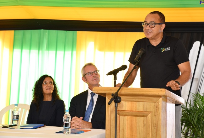 Minister of Health and Wellness, Dr. the Hon. Christopher Tufton (at podium), delivers the keynote address at the handover of the upgraded Mandeville Comprehensive Health Centre in Manchester, on July 13. Listening (from left) are Acting Pan American Health Organization (PAHO) Representative, Dr. Serene Joseph and the Caribbean Development Bank’s Development Director (UK) for the Caribbean, Foreign, Commonwealth and Development Office, Malcolm Geere.
