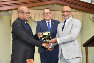 Minister of Health and Wellness, Dr. the Hon. Christopher Tufton (centre), looks on as Permanent Secretary in the Ministry, Dunstan Bryan, presents Pastor of Bethel Baptist Church, Rev. Dr. Glenroy Lalor, with a plaque during the Healthcare Workers Appreciation Month National Church Service held at the Church in Kingston on July 9. This is the second year that Healthcare Workers Appreciation Month is being recognised following the proclamation of the Governor General in 2022.