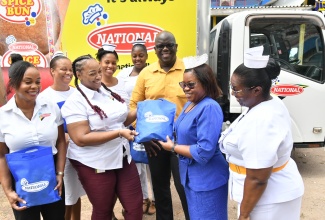 Director of Nursing Services at Bustamante Hospital for Children, Beverley Senior Berry (front, second right), receives a symbolic presentation of gift baskets and other products from National Baking Company Brand Manager, Marsha-Lee Stewart (front, second left), at the hospital on Wednesday (July 19). The presentation was in celebration of National Nurses’ Week and Healthcare Workers’ Appreciation Month. Sharing in the moment are National Baking Company Brand Manager, Crystal Blackwood (left); Acting Chief Executive Officer (CEO) of Bustamante Hospital for Children, Dwayne Francis (centre) and Nurse Michelle Finnikin-Campbell (right), while nursing staff share the moment in the background.