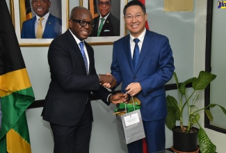 Minister of Labour and Social Security, Hon. Pearnel Charles Jr (right), presents a gift to Ambassador of the People