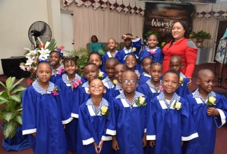 Portmore-based Youth Advocate, Claudine Duncan (right, back row), shares a moment with graduates of the Naggo Head Infant School in St. Catherine, during the school-leaving exercise held at the institution on Thursday (June 29).