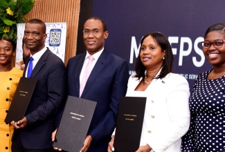 Minister of Finance and the Public Service, Dr. the Hon. Nigel Clarke (centre), displays the signed contract for The Mico University College’s Science, Technology, Engineering and Mathematics (STEM) scholarship, along with President of The Mico, Dr. Asburn Pinnock (second left), and Executive Director of the Students’ Loan Bureau (SLB), Nickeisha Walsh (second right). They are joined by Samantha Sterling (left), a beneficiary under the scholarship programme and mathematics teacher Erickay Chambers. Occasion was the recent launch of the scholarship programme at the Courtyard by Marriott Hotel in New Kingston.
