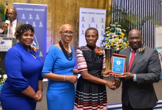 Minister of Education and Youth, Hon. Fayval Williams (second left), joins in the presentation of the Jamaica Teachers’ Association (JTA) Golden Torch Award to Melrose Cameron (second right) of DRB Grant Basic and Early Childhood Resource Centre, for 49 years of service to education. Handing over the award is General Manager of the TIP Friendly Society, Wilton South (right), while JTA President, La Sonja Harrison, shares in the moment. Two hundred and six teachers were recognised at the awards ceremony, which was held on Tuesday (July 11) at The Jamaica Pegasus hotel in New Kingston.