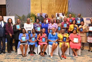 Minister of Education and Youth, Hon. Fayval Williams (seated third right), is flanked by recipients of the Jamaica Teachers’ Association (JTA) Golden Torch Award, during the awards ceremony held at The Jamaica Pegasus hotel in New Kingston on Tuesday (July 11). Also sharing in the moment are Former JTA President, Ray Howell (second row, left); Acting Chief Education Officer, Dr. Kasan Troupe (second row, second left) and JTA President, La Sonja Harrison (second row, sixth left). Two hundred and six teachers were recognised for giving a minimum of 35 years of service to education.