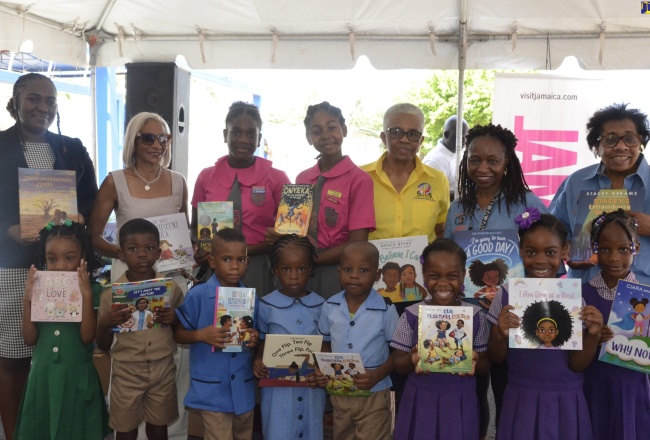 Children from schools across western Jamaica display books they received during the Blue World Travel Corp. Festival At Sea children’s book donation ceremony at the Montego Bay Cruise Port in St. James on July 28. Sharing the moment are (back row) Visitor Relations Manager, Jamaica Tourist Board (JTB), Candesa Cassanova (left); Business Development Manager, JTB Western USA Office, Dian Holland (second left); Founder, Sarah’s Children, Pamela Findlay (third right), President, Blue World Travel Corp, Patricia Yarbrough (second right) and Los Angeles Unified School District Administrator, Peggy Taylor Presley. Approximately 1,000 books were donated to students at 10 schools.
