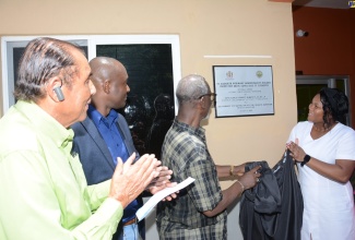 Minister of Local Government and Community Development, Hon. Desmond McKenzie (second right), assists the new Matron of the St. Elizabeth Infirmary, Bianca Mitchell (right), to unveil the plaque for the new administrative building at the infirmary in Santa Cruz that was officially opened on Monday, August 21. Also sharing the moment (from left) are Mayor of Black River, Councillor Derrick Sangster and Councillor for the Santa Cruz Division, Christopher Williams.
