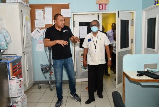 Minister of Health and Wellness, Dr. the Hon. Christopher Tufton (left), speaks with Clinical Coordinator at the Western Regional Health Authority (WRHA), Dr. Delroy Fray, during a tour of the Noel Holmes Hospital in Hanover, Lucea, on July 20.