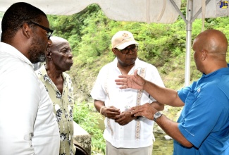 Minister of Tourism, Hon. Edmund Bartlett (second right), listens to a point being made by Member of Parliament for St. Thomas Western, James Robertson (right), while Executive Director of the Tourism Product Development Company (TPDCo), Wade Marrs (left) and Reggae Falls CEO, Antonio Porter, look on. Occasion was a destination assurance tour of St. Thomas on Thursday (June 22).
