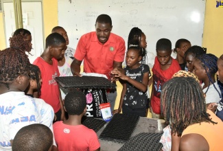 Instructor, Prince Palmer (centre), leads a seed tray demonstration during the Jamaica 4-H Clubs’ Summer Camp held at the club’s training centre on the Denbigh Showground in Clarendon from July 10-15.