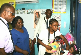 Ten-year-old Canadian-Jamaican philanthropist Jazmin Headley, points out some of the items she donated to set up the ‘Jazmin Corner’ at the Paediatric Ward of the May Pen Hospital in Clarendon, which was opened on Friday, August 11. Looking on (from left) are: Senior Medical Officer, Dr. Bradley Edwards; Acting Director of Nursing Services, Matron Nancy Davis-Williams; and Dr. Callistus Lawal.
