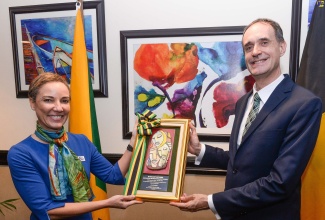 Minister of Foreign Affairs and Foreign Trade, Senator the Hon. Kamina Johnson Smith (left), presents a gift to outgoing Ambassador of Belgium to Jamaica, His Excellency Hugo Verbist, during a farewell luncheon for the diplomat at The Jamaica Pegasus hotel in New Kingston on Thursday (July 13).