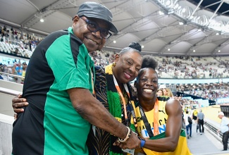 Jamaican sprinter, Shericka Jackson (right) is congratulated by the Minister of Culture, Gender, Entertainment and Sport, the Honourable Olivia Grange (centre) and the Minister of Tourism, the Honourable Edmund Bartlett (left) after setting a new championship record of 21.41 to win the women