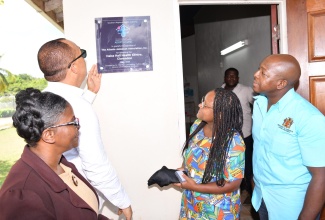 Minister of Health and Wellness, Dr. the Hon. Christopher Tufton (second left), and Minister of Labour and Social Security, Hon. Pearnel Charles Jr. (right), view a plaque unveiled at the Halse Hall Health Centre in Clarendon to commemorate the facility’s adoption by the United States (US)-based Atlanta-Jamaica Association (AJA). Dr. Tufton formally announced the arrangement, being facilitated under the Government’s Adopt-A-Clinic Initiative, during a ceremony at the centre on Friday (August 4). Others (from left) are Public Health Nurse, Clarendon Health Department, Karen Nelson-Senior; and AJA representative, Althea Fatuga. The Halse Hall Health Centre is located in Clarendon South eastern, for which Minister Charles is the Member of Parliament.