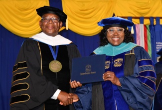 Northern Caribbean University (NCU) President, Professor Lincoln Edwards (left), presents Cabinet Secretary, Audrey Sewell, with the Honorary Doctor of Public Service Degree during the institution’s 100th commencement exercise at its Mandeville campus in Manchester on Sunday (August 13).
