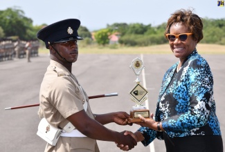 Permanent Secretary in the Ministry of National Security, Ambassador Alison Stone Roofe (right), presents the Commandant’s Award to Private (NS) R. Richards, for achieving the highest overall average during training. Occasion was the Passing Out Parade for the Jamaica National Service Corps (JNSC) Intake 2022/02, held on Friday (July 21) at the Polo Grounds, Up Park Camp in Kingston.