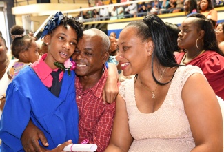 Parents of New Providence Primary School’s 2023 Top Girl for the Primary Exit Profile (PEP), Lucinana Morris (left), Kayden Cassie and Alfred Morris, congratulate their daughter after she collected her school-leaving certificate during the graduation ceremony held at the University of Technology (Utech) campus in St. Andrew on Friday (June 30).