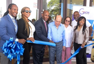 Minister of Industry, Investment and Commerce, Senator the Hon. Aubyn Hill (third left) and Chairman, Portmore Holdings Limited, Gordon Tewani (centre), cut the ribbon to open IBEX Global Jamaica’s new facility located in Building Two at the GTECH Park in Portmore, St. Catherine, on Wednesday (July 5). Joining them (from left) are Member of Parliament, St. Catherine East Central, Hon. Alando Terrelonge; Chief Executive Officer, Strength Construction Limited, Carelene Bailey; Diana Tewani; Senior Vice President of Operations and Jamaica Country Manager, IBEX Global, Tamara Ricketts-Brown, and Councillor for the Waterford Division, Fenley Douglas.