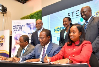 Minister of Finance and the Public Service, Dr. the Hon. Nigel Clarke (seated, centre), Acting Deputy President, University of Technology (UTech) Jamaica, Professor Haldane Johnson (seated, left), and Executive Director, Students’ Loan Bureau (SLB), Nickeisha Walsh (seated, right), affix their signatures to the Memorandum of Understanding that will facilitate the provision of 1,000 Government of Jamaica (GOJ) Science, Technology, Engineering and Mathematics (STEM) scholarships, valued $2.4 billion, over the next five years. Observing the proceedings (from left) are UTech Jamaica Chancellor, Lloyd Carney; Dean of the University’s Faculty of Engineering and Computing, Professor Sean Thorpe, and Minister of State in the Ministry of Education and Youth, Hon. Marsha Smith. The occasion was the launch of the scholarships on Thursday (July 6) at The Jamaica Pegasus hotel in New Kingston.