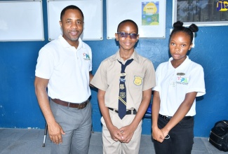 Principal of St. Ann’s Bay Primary, Trevor Cole (left), shares a moment with top-performing boy and girl in the 2023 sitting of the Primary Exit Profile (PEP) examination, 11-year-old Daniel Hall and 11-year-old Aaylia Miller.