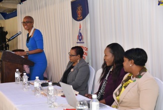 Minister of Education and Youth, Hon. Fayval Williams (at podium), addresses a back-to-school conference held on July 11, at the Terra Nova All-Suite Hotel in St. Andrew. Listening (from left) are Education Officer with the Ministry, Marcia Higgins; Acting Chief Education Officer, Dr. Kasan Troupe, and Regional Director with the Ministry, Sophia Forbes Hall.