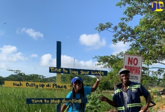 Customer Relations Officer at WPM Waste Management Limited, Sharnon Williams (left), and WPM Sanitation Officer, Roshaun Dick, participate in beautification work after the agency eliminated a dump site in Clark’s Town, Trelawny on Wednesday (July 26).  