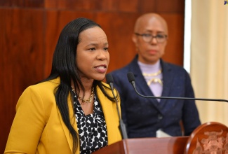 Acting Chief Education Officer in the Ministry of Education and Youth, Dr. Kasan Troupe, responds to a question during Wednesday`s (August 16) post-Cabinet press briefing at Jamaica House. At right is Minister of Education and Youth, Hon. Fayval Williams.