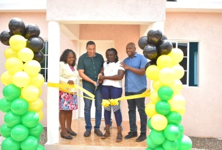 Prime Minister, the Most Hon. Andrew Holness (second left) and beneficiary under the New Social Housing Programme (NSHP) Kadian Campbell (second right), cut the ribbon to hand over the newly built three-bedroom home in Darlow District in Ashely, Clarendon, on Wednesday (July 12). Sharing the moment (from left) are Chairperson, Oversight Committee of the NSHP, Judith Robb Walters and Member of Parliament, Clarendon South Western, Lothan Cousins.