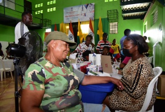 Resident of Olympic Gardens, Elizabeth Reid (left) is having her blood pressure checked by practical nurse, Althea Brown, at a medical camp staged by the Indian High Commission at the Olympic Gardens Civic Centre in St. Andrew West Central on Sunday (Sept. 10).