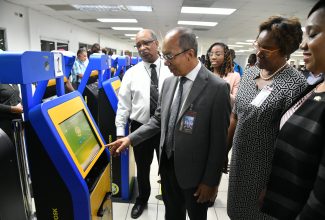 Minister of National Security, Hon. Dr. Horace Chang (second left), accesses the new Immigration/Customs (C5) Form at a kiosk at the Norman Manley International Airport (NMIA) in Kingston on Tuesday (September 5). Looking on (from left) are Chief Executive Officer of the Passport, Immigration and Citizenship Agency (PICA), Andrew Wynter; Permanent Secretary in the Ministry of National Security, Ambassador Alison Stone Roofe; and Chief Executive Officer and Commissioner of Customs, Jamaica Customs Agency (JCA), Velma Ricketts Walker.