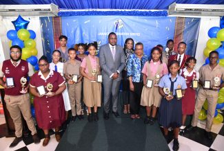 Minister without Portfolio in the Office of the Prime Minister with Responsibility for Information, Hon. Robert Morgan (centre), and Chief Executive Officer of the Jamaica Information Service (JIS), Enthrose Campbell (eighth right), are surrounded by finalists in the JIS’s 2022 Heritage Competition, at the awards ceremony held at the Terra Nova All-Suite Hotel in St. Andrew. Representative of competition co-sponsor, GK Insurance, Janell Myers (ninth right), also shared in the occasion.