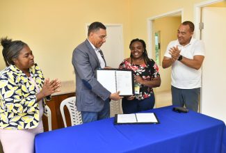 Prime Minister, the Most Hon. Andrew Holness (second left), and new homeowner Shanice Leslie (second right) display the social contract for the two-bedroom unit, which was developed under the New Social Housing Programme (NSHP) at a handover ceremony at Old Road, St. Catherine, on Wednesday (September 13). Others sharing the moment (from left) are Chairperson for the Oversight Committee of the NSHP, Judith Robb Walters, and Member of Parliament for St. Catherine West Central, Dr. the Hon. Christopher Tufton.

 