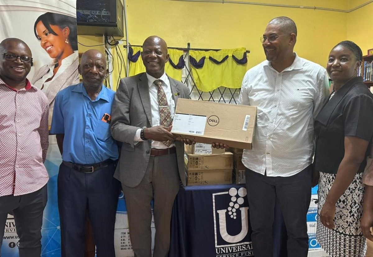 Chief Executive Officer, Universal Service Fund (USF), Dr. Daniel Dawes (centre), hands over desktop computers to the Huntley Library and Huntley Primary and Infant School in Manchester. Receiving the devices are Member of Parliament for Manchester North Western, Mikael Phillips (second left), and Senior Librarian of Huntley Parish Library, Michelle Barnes-Pitter (right). Others (from left) are Councillor/Candidate, Devon Wilson; and Councillor, Spur Tree Division, Manchester Municipal Corporation, Ervin Facey.

