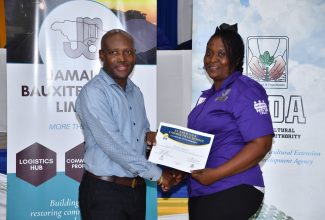 Chief Technical Director in the Ministry of Agriculture, Fisheries and Mining, Courtney Cole,  presents a certificate to Nordia Greaves, at the Rural Agricultural Development Authority (RADA) Farmer Field School Graduation Ceremony, held at Moneague College, St Ann, on Thursday (February 7).