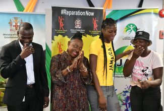 Minister of Culture, Gender, Entertainment and Sport, Hon. Olivia Grange (second left), celebrates with National Netball Player, Latanya Wilson (second right) and her mother, Carol Dick (right), after presenting them with documents to a new home. The handover took place at the Ministry in New Kingston on September 7. Sharing the moment is Permanent Secretary in the Ministry, Denzil Thorpe.