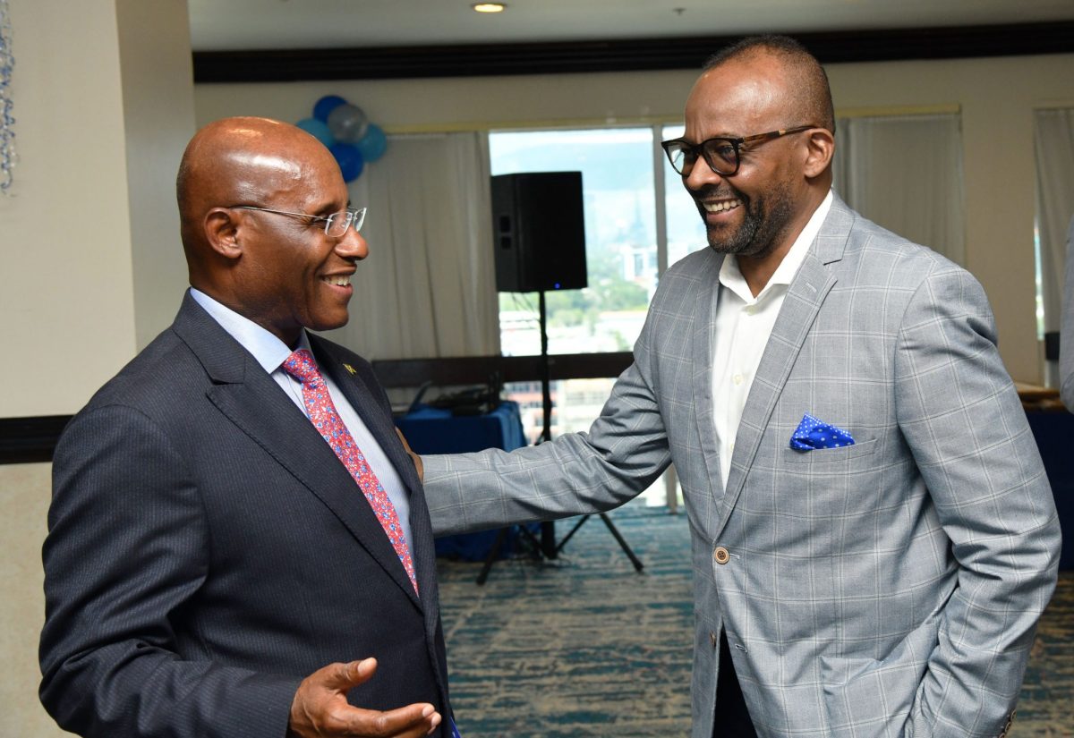 Minister of Industry, Investment and Commerce, Senator the Hon. Aubyn Hill (left), converses with Fair Trading Commission (FTC) Chairman, Donovan White (right), during the FTC’s 30th anniversary Commissioners and Staff Luncheon and Long Service Awards Ceremony,  at The Jamaica Pegasus hotel in New Kingston on Thursday (September 14).