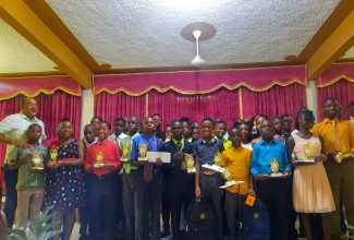 Minister of Health and Wellness, and Member of Parliament (MP) for St Catherine West Central,  Dr. the Hon. Christopher Tufton (left), with some of the 39 students from primary and high schools, as well as tertiary institutions, who received educational support from the MP, at a recent back-to-school event, held at the Watermount Open Bible Church in St. Catherine. Nestlé Jamaica Limited also awarded each Primary Exit Profile (PEP) student with $10,000.