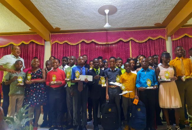 Minister of Health and Wellness, and Member of Parliament (MP) for St Catherine West Central,  Dr. the Hon. Christopher Tufton (left), with some of the 39 students from primary and high schools, as well as tertiary institutions, who received educational support from the MP, at a recent back-to-school event, held at the Watermount Open Bible Church in St. Catherine. Nestlé Jamaica Limited also awarded each Primary Exit Profile (PEP) student with $10,000.