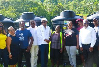 Minister of Tourism, Edmund Bartlett (fifth left), shakes the hand of farmer Keithay Jackson (sixth left) during a presentation of fifty 650-gallon water storage tanks to South Trelawny farmers in Ulster Spring on Saturday, September 2, 2023.  The Tourism Enhancement Fund is funding the tanks, which will aid farmers in increasing food production for the tourism sector.  Sharing the occasion are (from left) Director of the Tourism Linkages Network in the Tourism Enhancement Fund, Carolyn McDonald Riley; Member of Parliament for Trelawny South, Hon. Marisa Dalrymple-Philibert; and farmers Lenford Forbes, Tristan Turner, Geneva Edwards; and the Mayor of Falmouth, Councillor Colin Gager.

